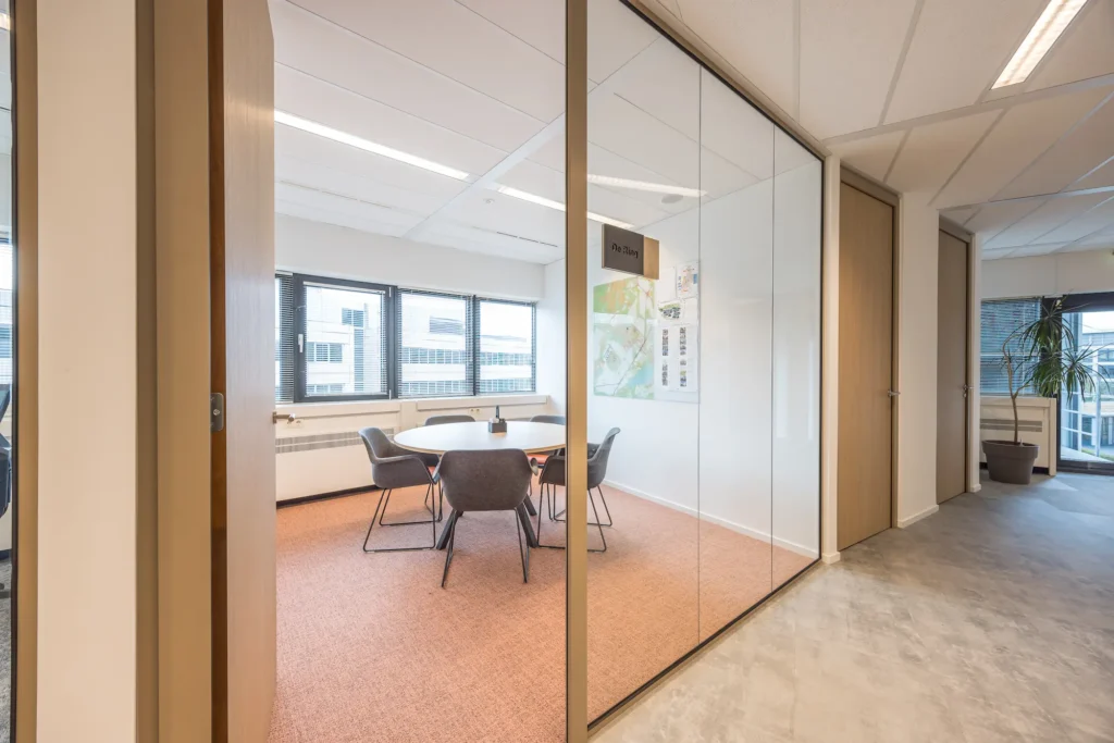 Vergaderruimte bij Zorggroep Haarlemmermeer met een ronde tafel en vier stoelen.