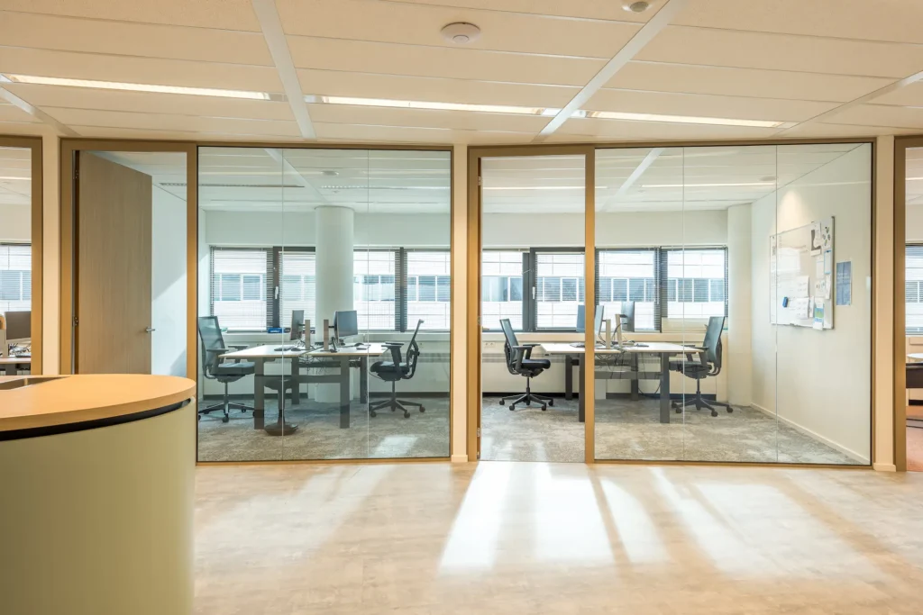 Moderne kantoorruimte met glazen wanden bij Zorggroep Haarlemmermeer.