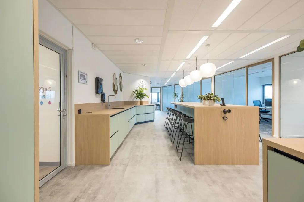 Een moderne kantoorruimte van Zorggroep Haarlemmermeer met een strak interieur, houten details en planten.