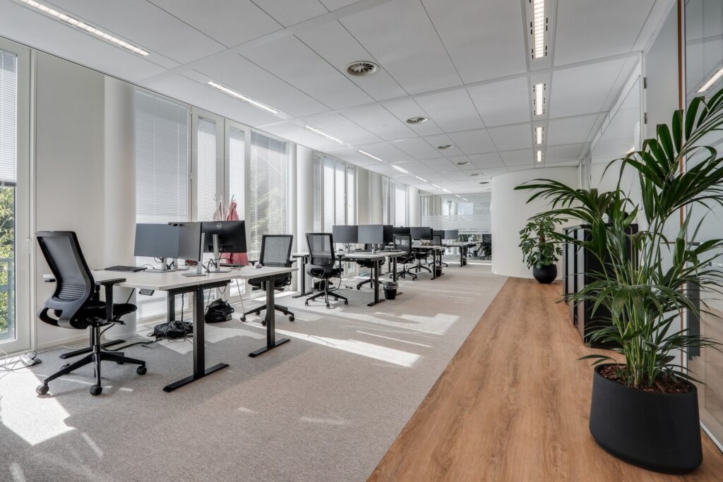 Een moderne en lichte kantoorruimte met lege bureaus en ergonomische stoelen aan de Decuserstraat 89.
