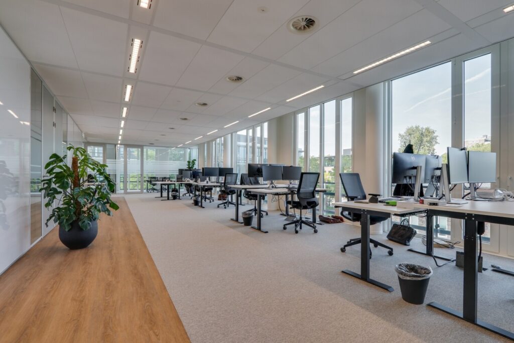 Moderne, lichte kantoorruimte met werkplekken en grote ramen aan de Decuserstraat 89-11.
