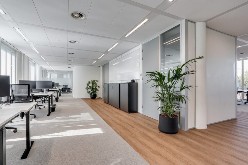 Moderne en ruime kantoorruimte met werkplekken en groene planten, gelegen aan de Decuserstraat 89.