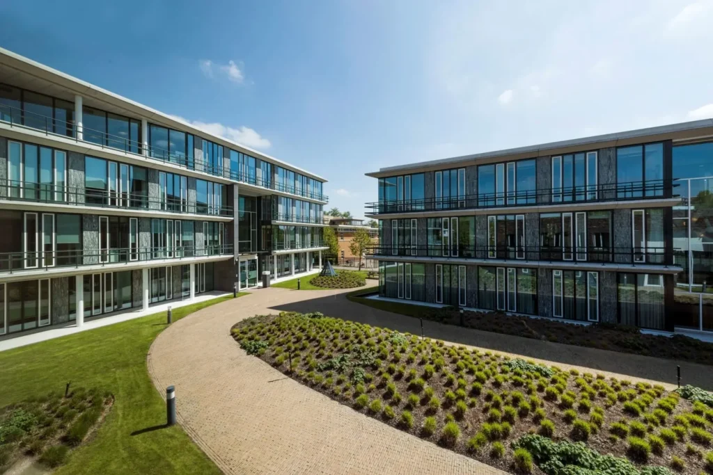 Moderne kantoorgebouwen aan de Decuserstraat 89-23 omgeven door groen en een uitgestrekte tuin.