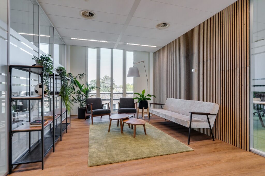 Moderne kantoorruimte met houten lamellenmuur, glas, stijlvolle meubels en planten bij Decuserstraat 89.