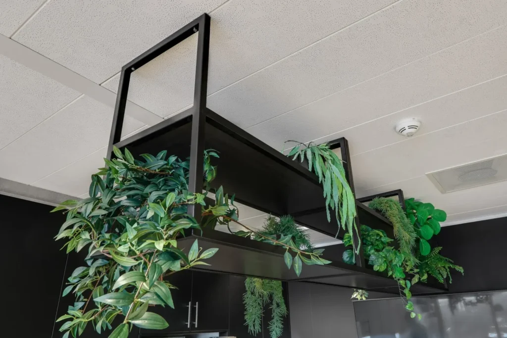 Een moderne hangende plantenbak met weelderig groen in een kantooromgeving aan het plafond van Gustav Mahlerlaan 17.