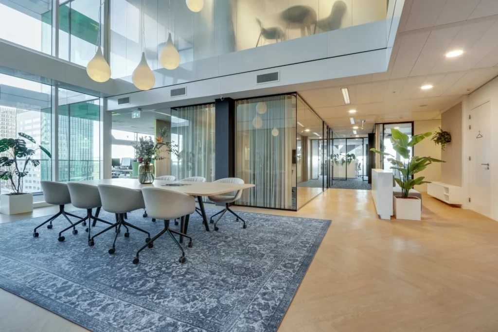Moderne vergaderruimte met glazen wanden, designstoelen en hanglampen in een zakelijke omgeving aan de Gustav Mahlerlaan.