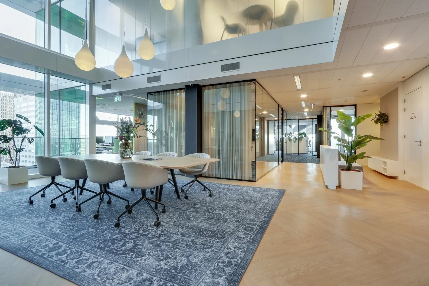 Moderne vergaderruimte met glazen wanden, designstoelen en hanglampen in een zakelijke omgeving aan de Gustav Mahlerlaan.