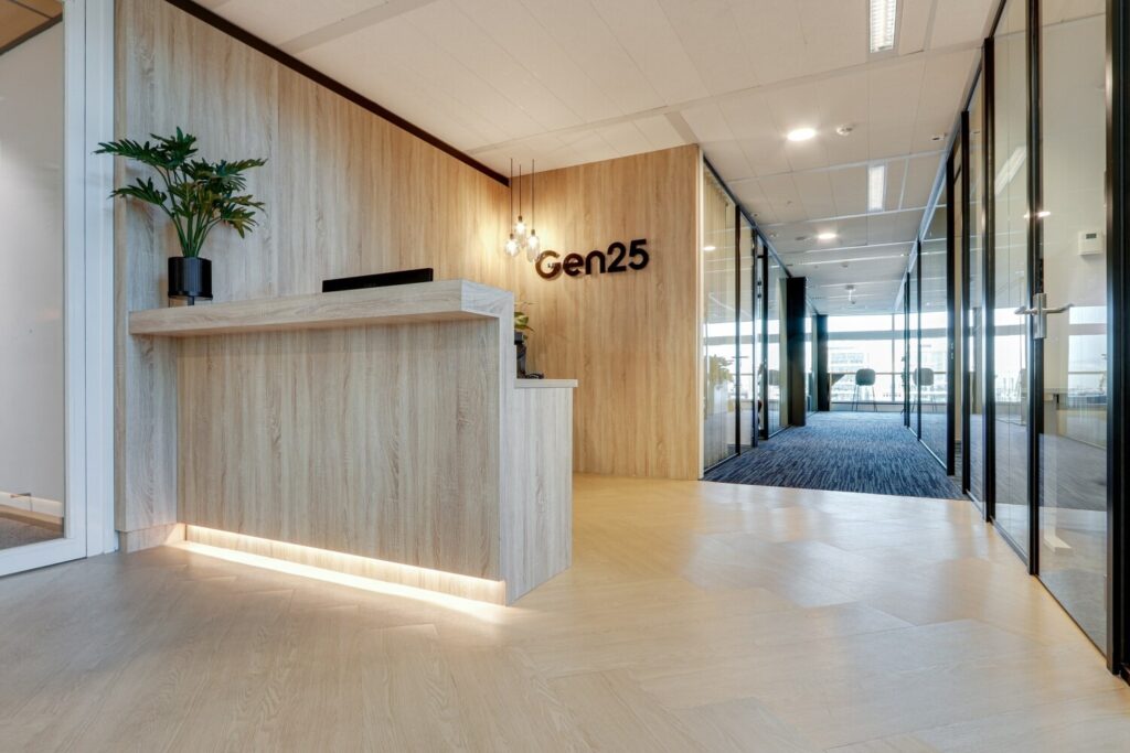Ontvangstbalie en ingang van het kantoor van Gen25 met houten interieur en moderne verlichting.