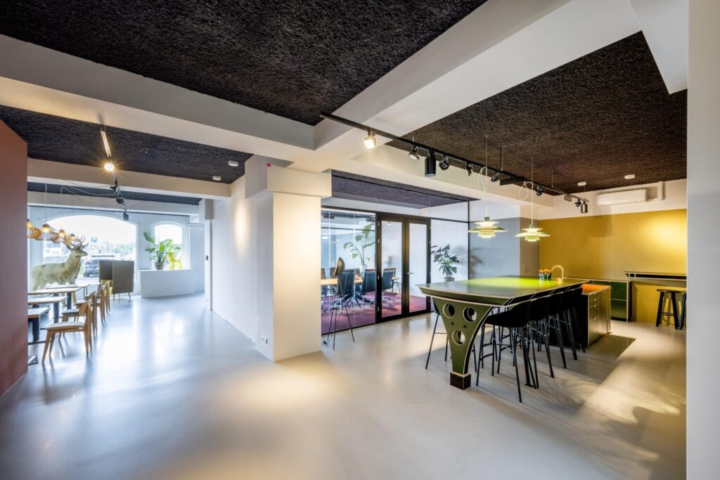 Modern en licht kantoorinterieur met vergaderruimte, groene bar en decoratief rendier.