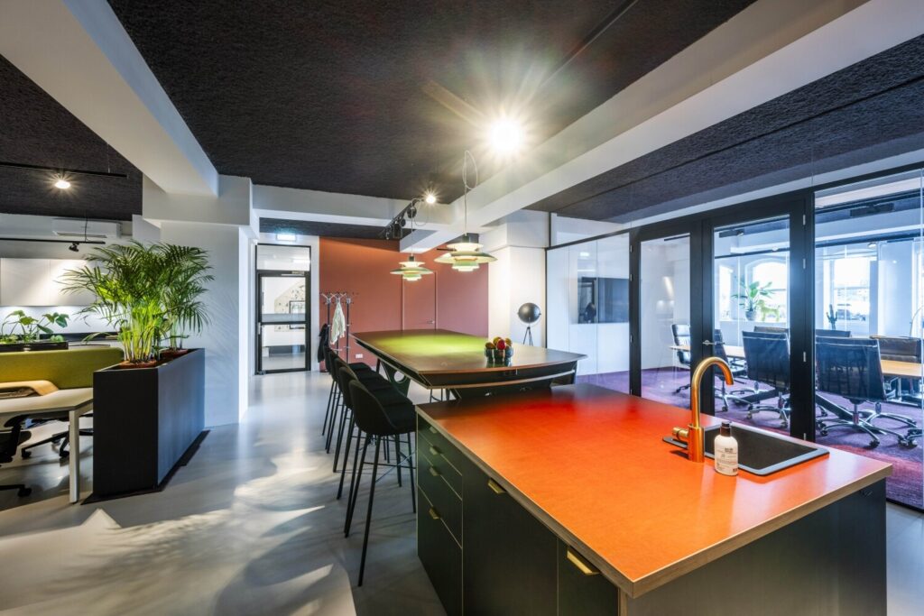 Modern ingerichte kantoorruimte met biljarttafel, keuken en vergaderkamer.