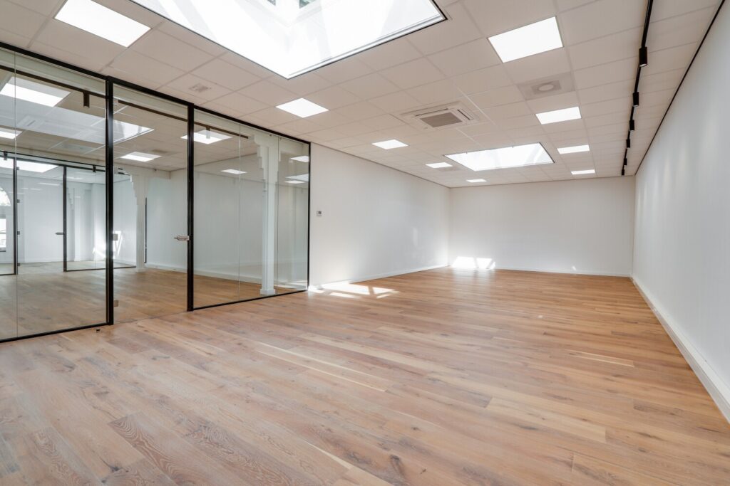 Lichte en ruime kantoorruimte met glazen wanden en houten vloeren aan de Keizersgracht 209-11.
