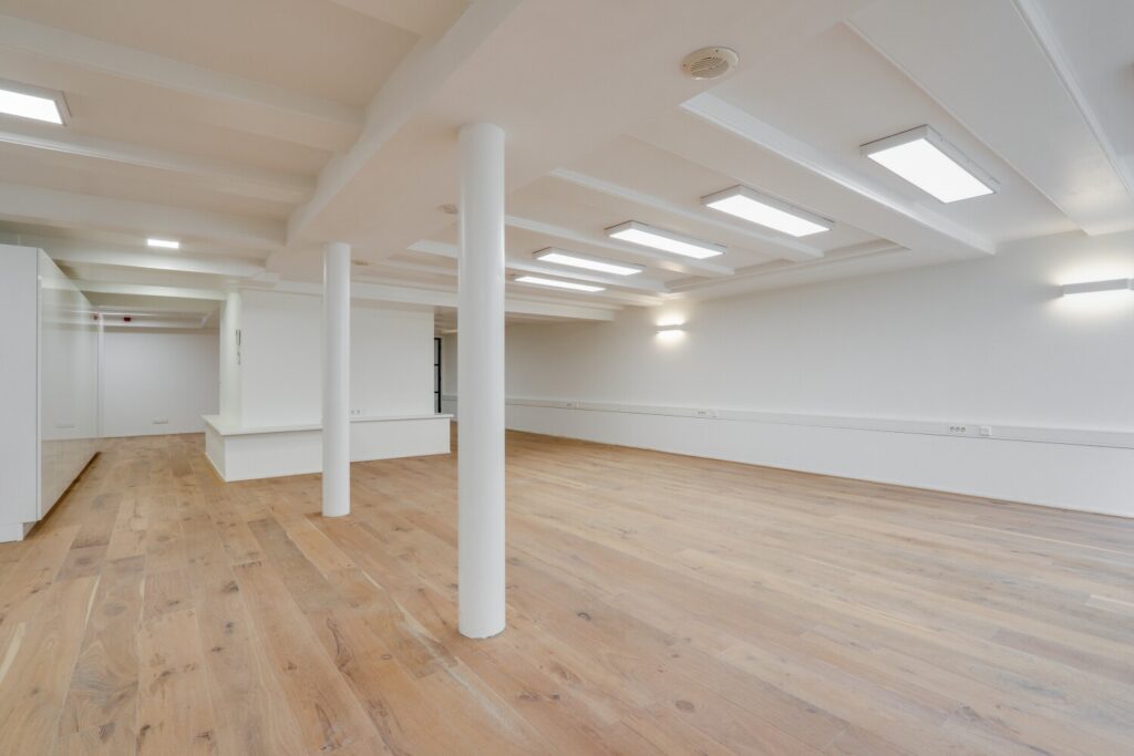 Leeg kantoorpand aan de Keizersgracht 209 met houten vloer en moderne verlichting.