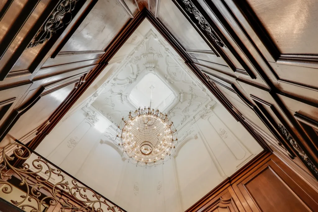 Decoratieve houten wanden en een elegante kroonluchter in een historisch pand aan de Keizersgracht 209.