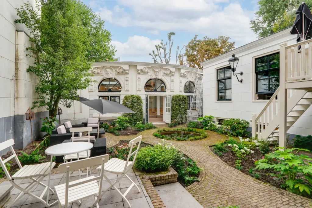 Prachtige tuin aan de Keizersgracht 209 met klassieke geveldecoraties en een uitnodigend terras.