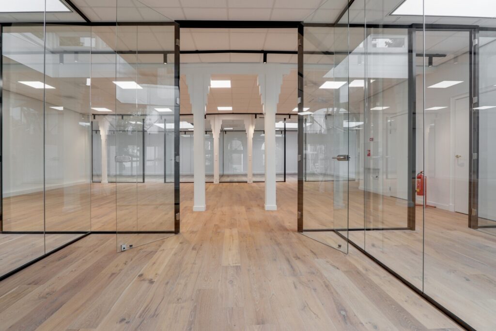 Licht en modern interieur van een kantoorruimte aan de Keizersgracht 209, met glazen wanden en houten vloeren.