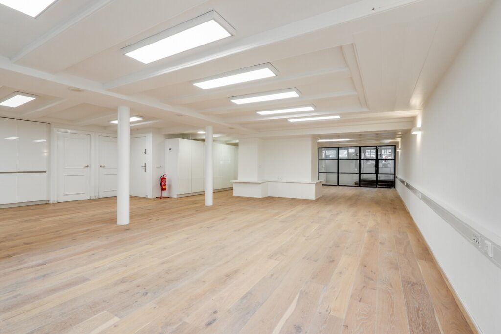 Lichte, ruime kantoorruimte met houten vloer aan de Keizersgracht 209 in Amsterdam.