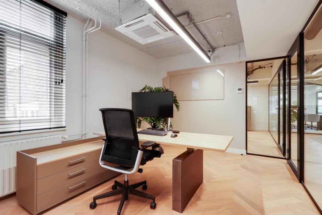 Modern kantoorinterieur met een minimalistisch bureau, ergonomische stoel en glazen wanden bij Singel 13.