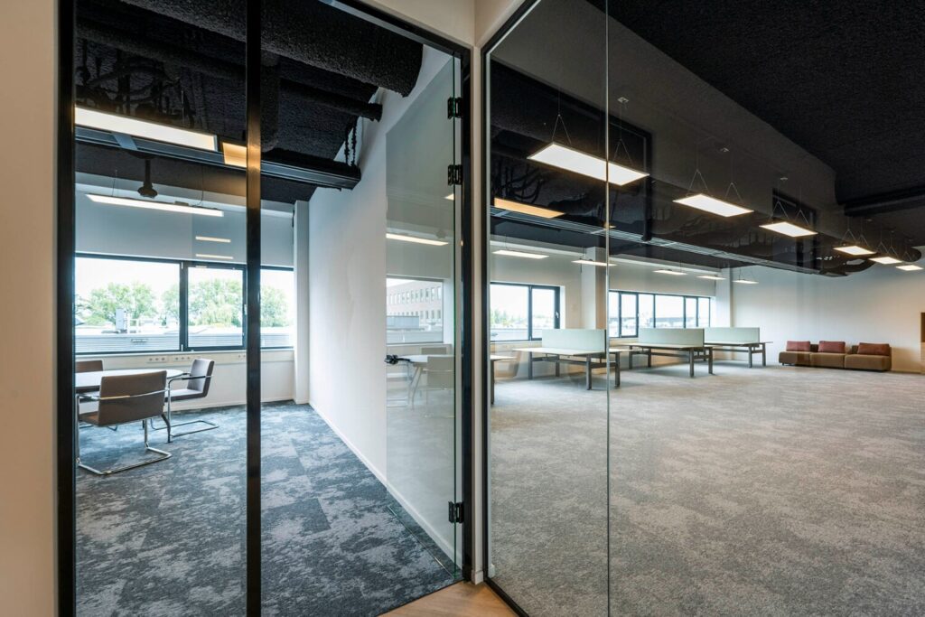 Moderne kantoorruimte bij Transformatorweg 76-13 met glazen wanden en ruime werkplekken.