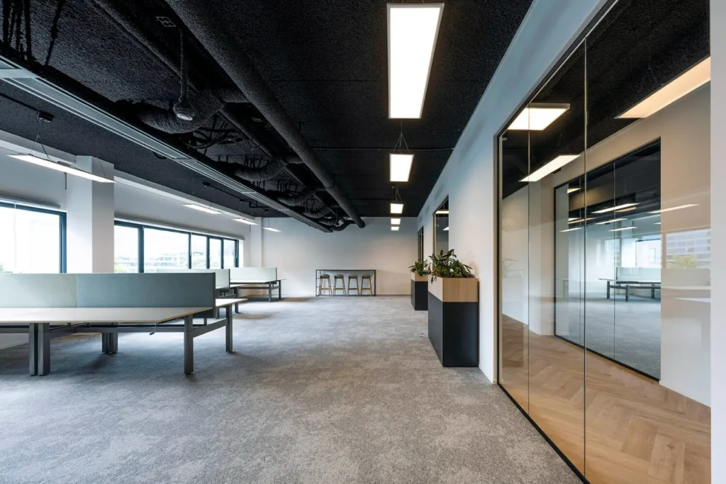 Modern kantoorinterieur met open werkplekken en glazen wanden op Transformatorweg 76.
