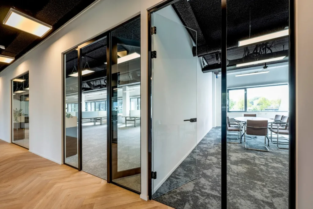 Moderne kantoorruimte met glazen wanden en een vergadertafel op Transformatorweg 76.
