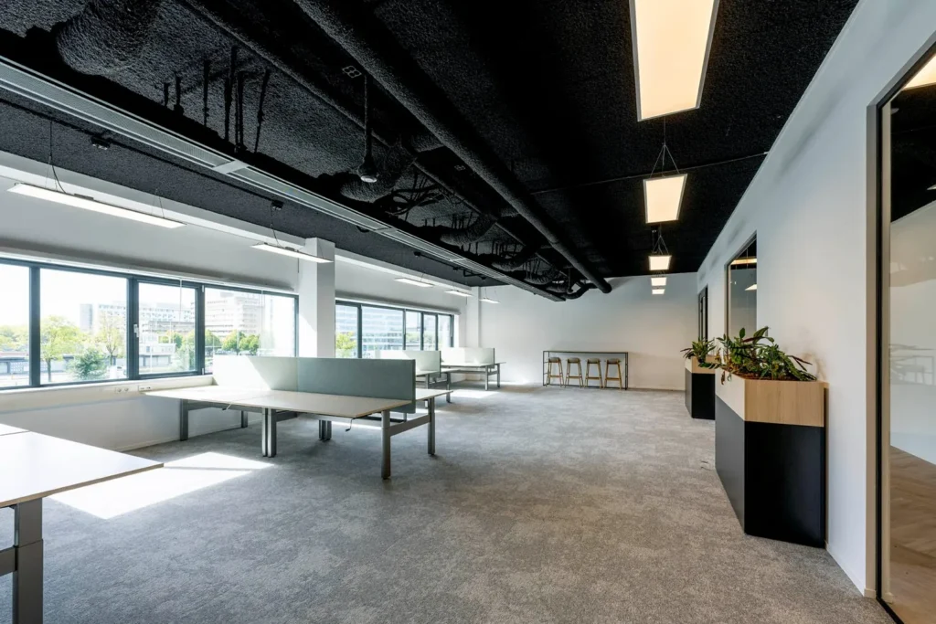 Moderne kantoorruimte aan de Transformatorweg met flexibele werkplekken en groot raam met uitzicht.