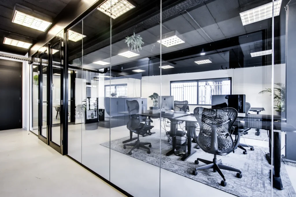 Een modern kantoor met glazen wanden en ergonomische bureaustoelen in een lichte en ruime omgeving.