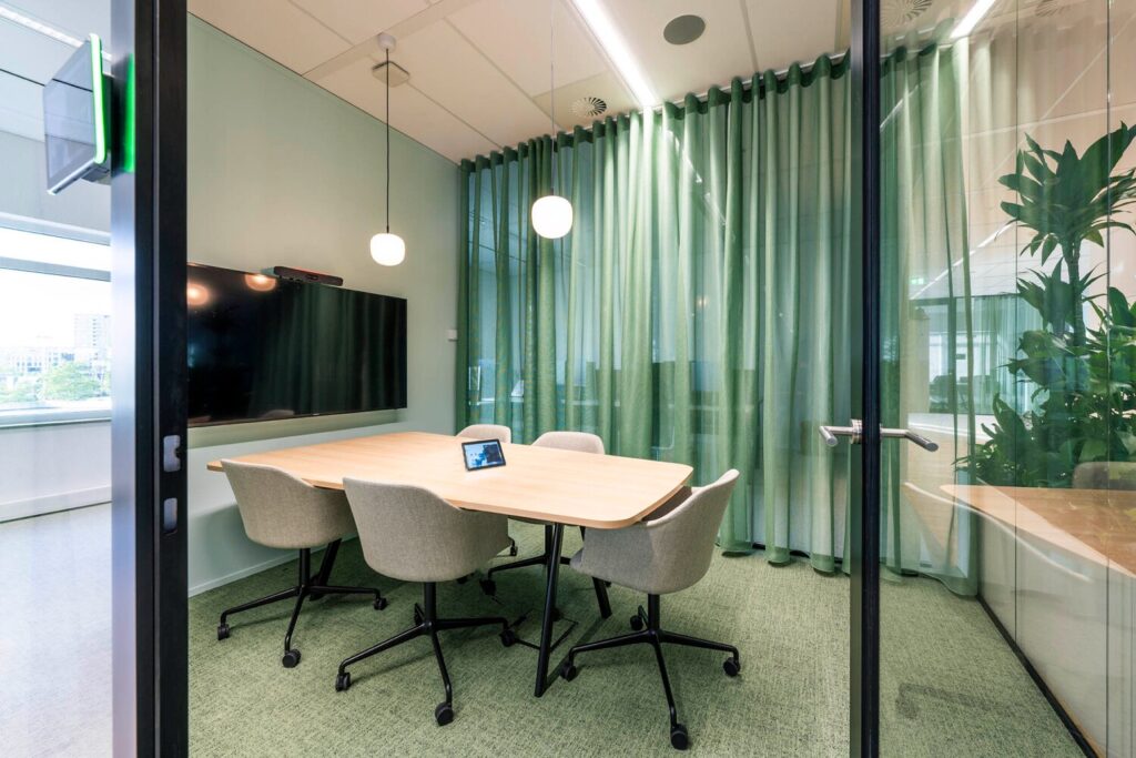 Moderne vergaderruimte met een houten tafel, comfortabele stoelen en groen decor aan de Winthontlaan 18.