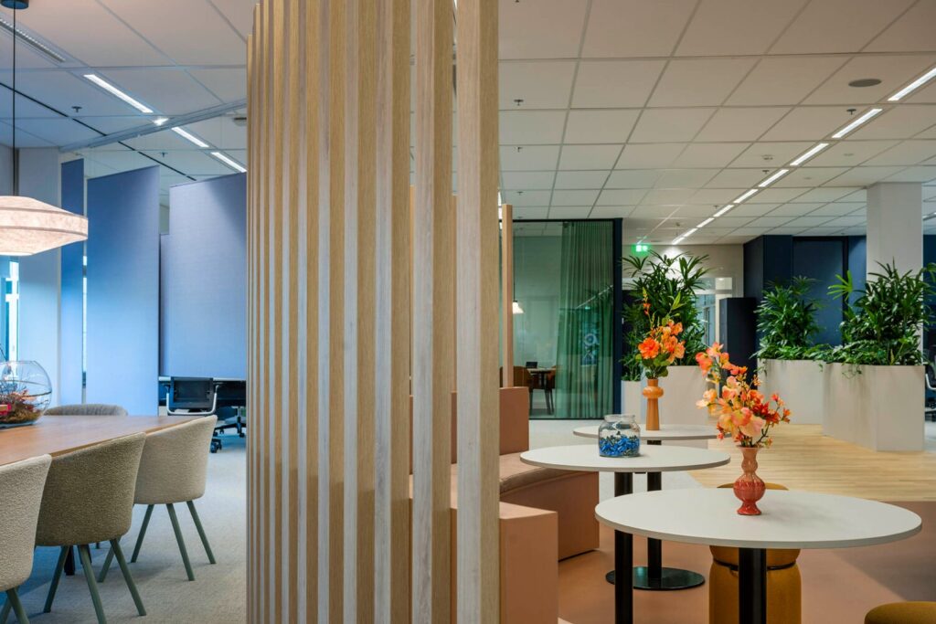 Modern kantoorinterieur met houten scheidingswand, kleurrijke bloemen en planten bij Winthontlaan 19.