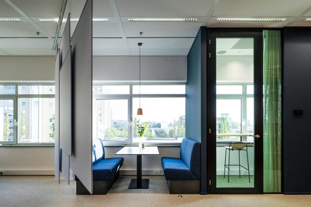 Een moderne kantoorruimte met een lichte zithoek en glazen deur aan de Winthontlaan 9.